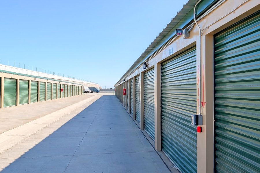 Row of drive-up self storage units with green doors at Wasco Mini Storage, California